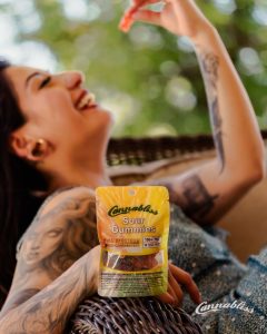 Embark On A Journey Cianna eating Sour Gummies on the porch Cannabliss, Halo Infusions edibles