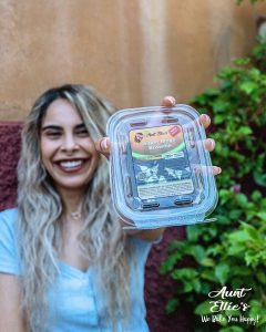 Natural Relief Aunt Ellie's Brianna holding up the super mega brownie with a smile. Halo Infusions. Tucson edibles