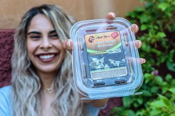 Natural Relief Aunt Ellie's Brianna holding up the super mega brownie with a smile. Halo Infusions. Tucson edibles