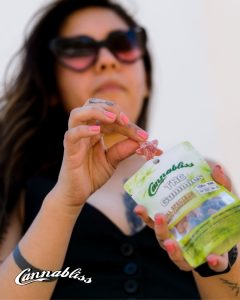 Experience the Entourage Effect Cannabliss THC gummiesHilda pulling out a red THC Gummie pink nails. tucson edibles