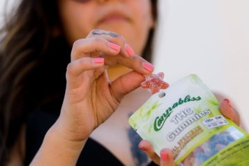 Experience the Entourage Effect Cannabliss THC gummiesHilda pulling out a red THC Gummie pink nails. tucson edibles